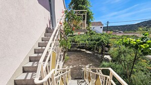 Una escalera que lleva a un edificio con vistas a un jardín y una ladera.