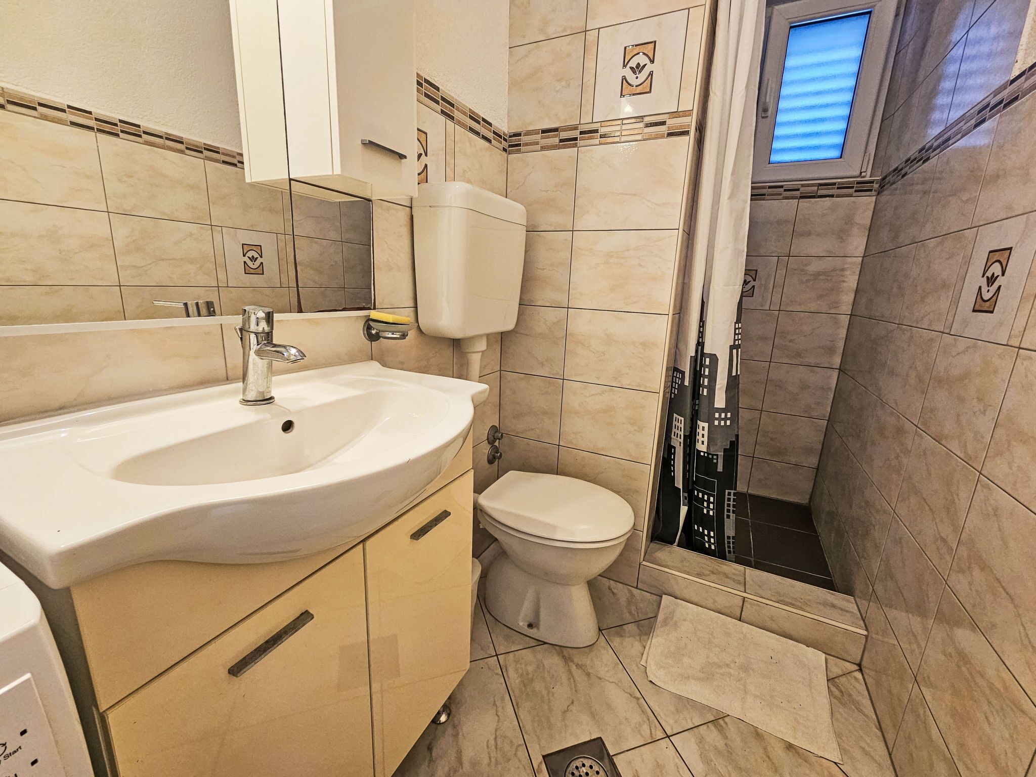 Ein Badezimmer mit Waschbecken, Toilette und Dusche.