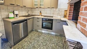 Cocina compacta con lavavajillas, horno y cafetera.
