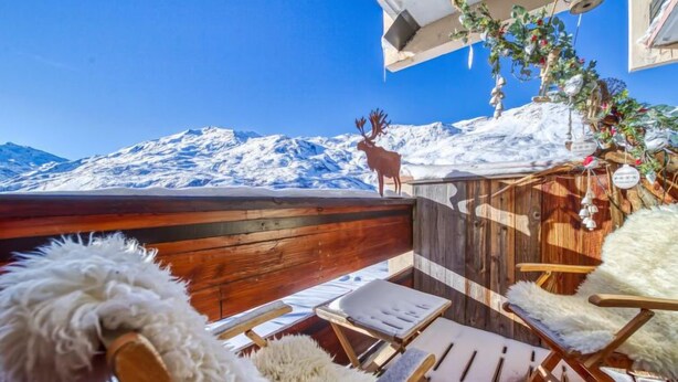 A wooden deck with lounge chairs and a view of snow-covered mountains. - Belleville Caron 1 - 1213 by Interhome (Les Menuires)
