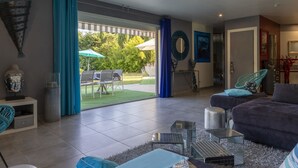 A modern living room with a large sliding glass door leading to an outdoor patio. - Un petit coin de paradis by Interhome (Châteaurenard)