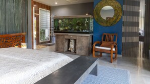 A modern bedroom with a large bed, a fish tank, a wooden chair, and a decorative mirror. - Un petit coin de paradis by Interhome (Châteaurenard)