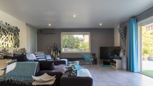 A spacious living room with a large window, a flat-screen TV, and a seating area with a sofa and chairs. - Un petit coin de paradis by Interhome (Châteaurenard)