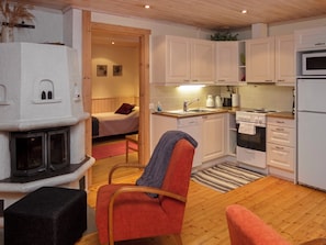 A compact living space with a kitchenette, a fireplace, and a cozy seating area. - Suopursu by Interhome (Kuusamo)