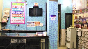 A reception area with a sign listing services like air tickets and car rentals.