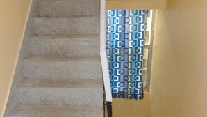 A staircase with beige carpeted steps leading to a landing.