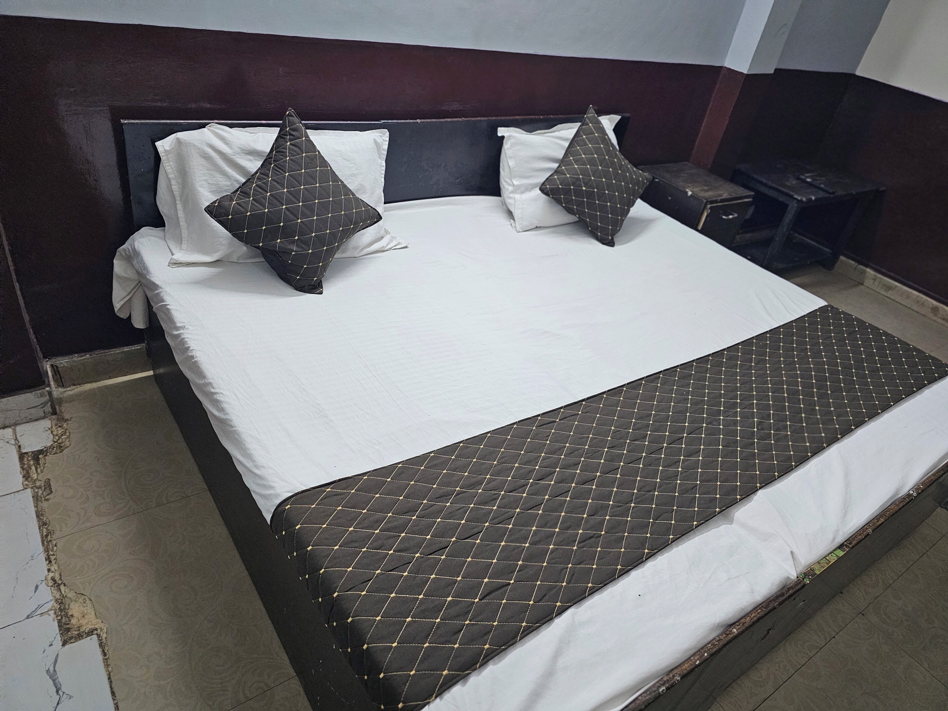 A bed with a quilted bedspread, two pillows, and a headboard.