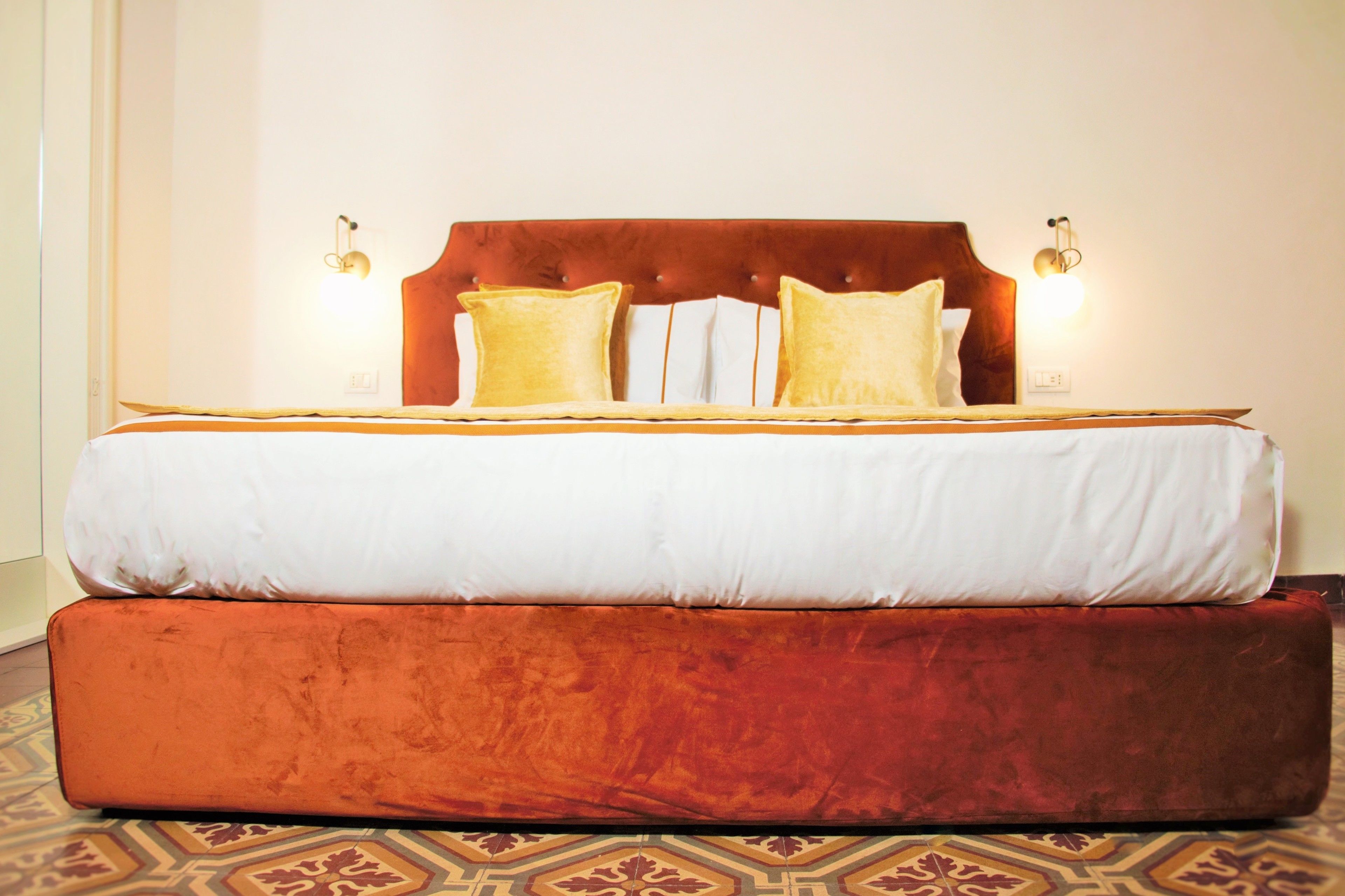 A large bed with a wooden headboard and two bedside lamps.