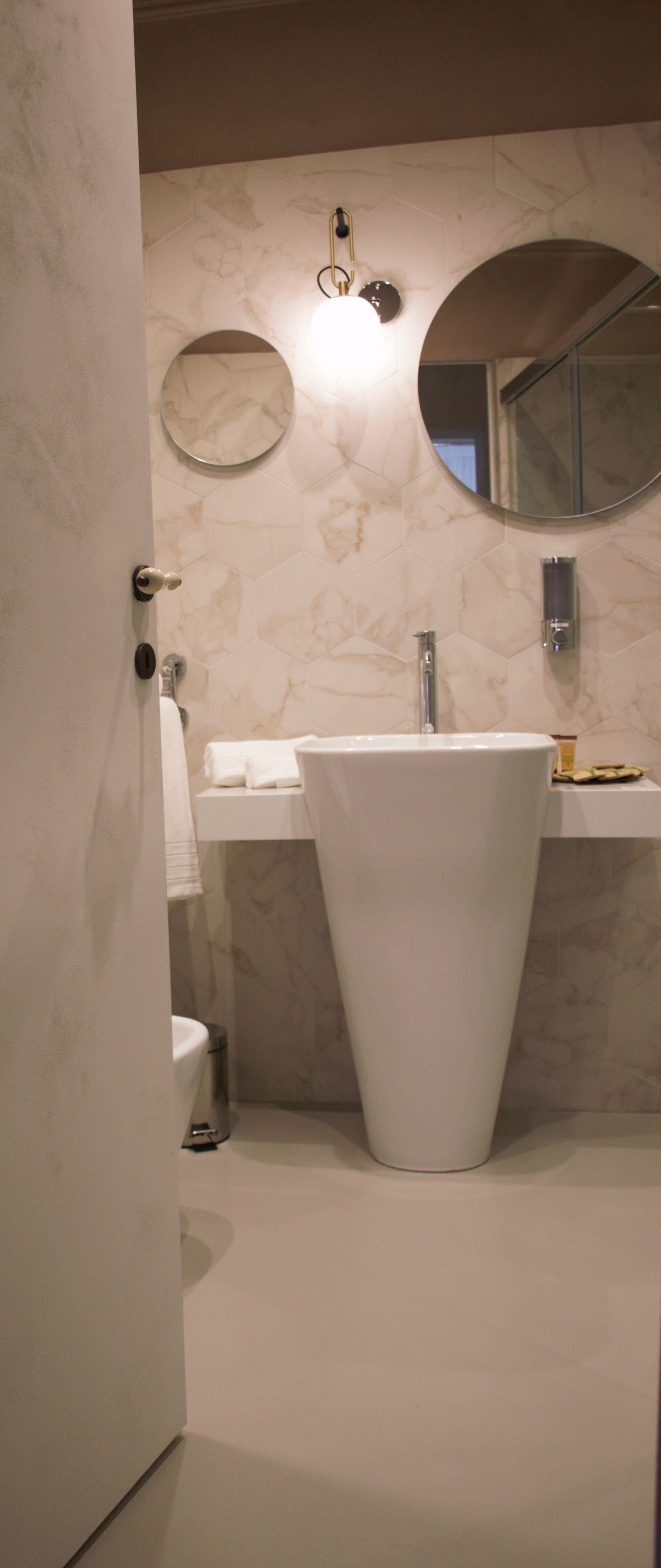 A bathroom with a white sink, a toilet, and a mirror on the wall.