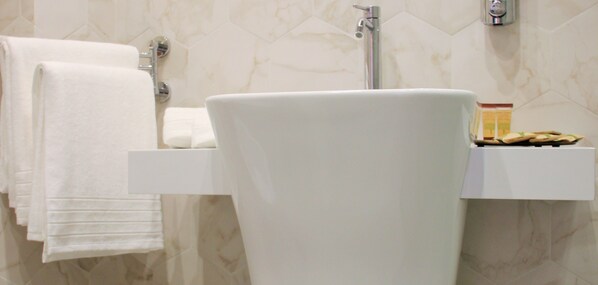 A bathroom with a white sink, a towel rack, and a soap dish.