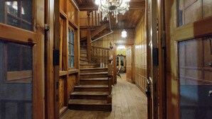 A wooden staircase leading to a room with a chandelier. - Shimla British Resort (Shimla)