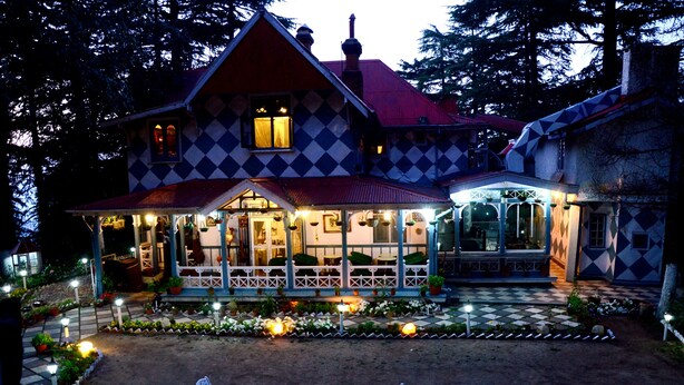 A large, checkered house with a porch and outdoor seating area. - Shimla British Resort (Shimla)