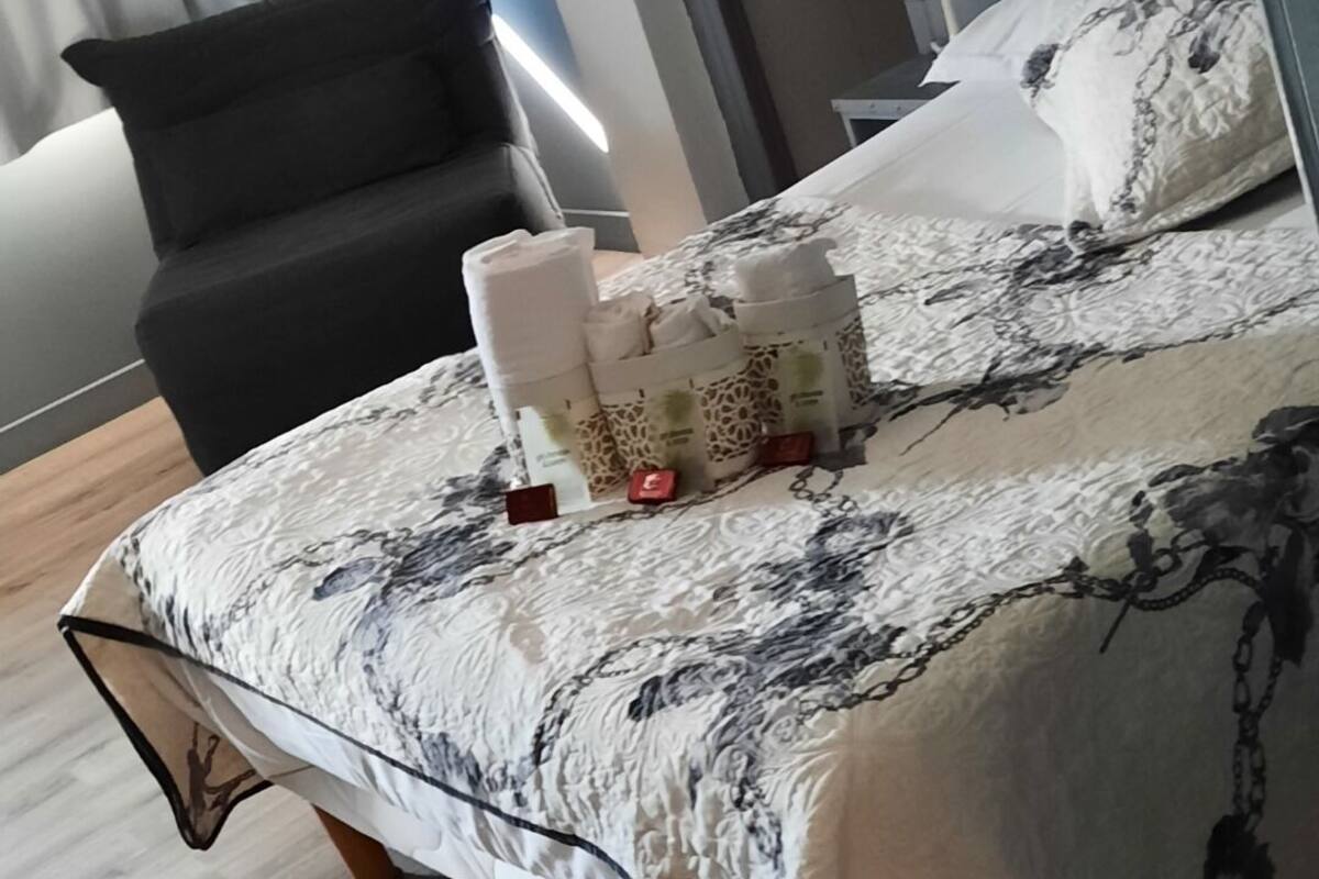Ein modernes Schlafzimmer mit einem Bett, einem Sessel und einem Nachttisch.