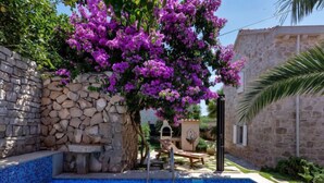 A swimming pool with stone walls and a stone building in the background. - Marijan by Interhome (Brač/Sutivan)