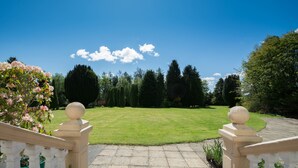 A paved pathway leading to a well-maintained lawn with a clear blue sky and scattered clouds. - Kirroughtree Country House B&B (Newton Stewart)