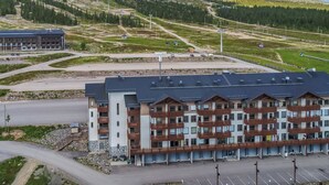 Een hotel met meerdere verdiepingen, modern van ontwerp, met balkons en een parkeerplaats.