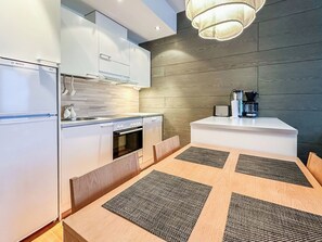 A modern kitchen with white cabinetry, a built-in oven, and a coffee machine on a counter. - Ski chalets 6203 by Interhome (Ylläsjärvi)