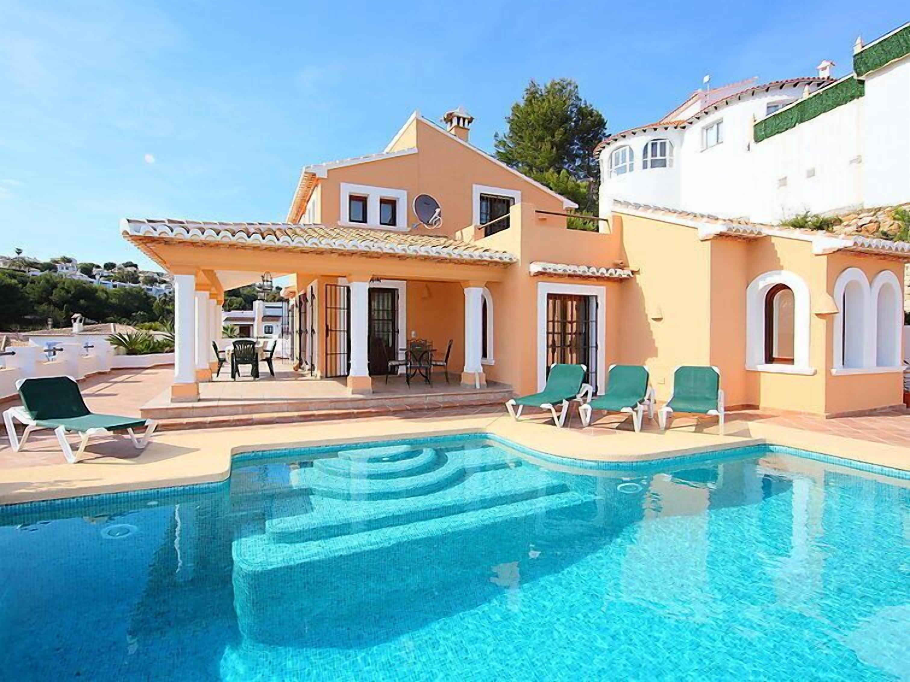 Una casa de dues plantes amb piscina, zona d'estar a l'aire lliure i un porxo cobert.