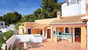 A Mediterranean-style villa with a tiled patio, outdoor seating, and a small kitchen area. - Ca Toni by Interhome (Moraira)