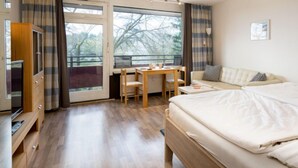 Un dormitorio con cama, escritorio, silla, sofá y armario.