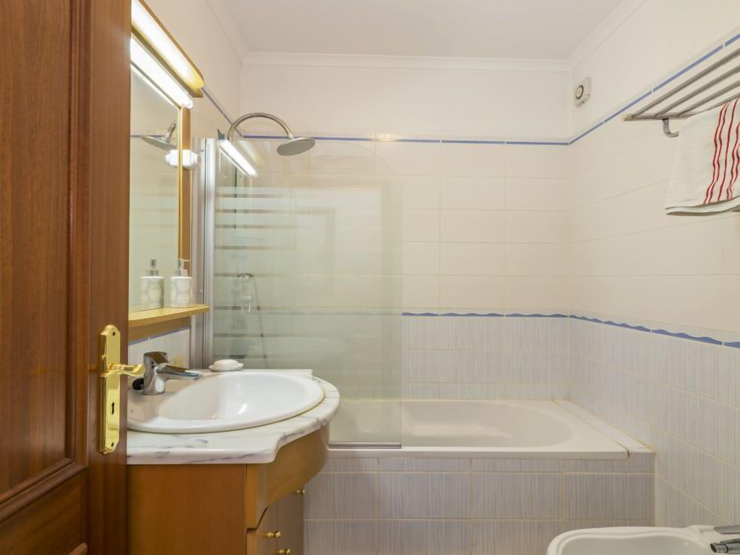 Une salle de bain avec un lavabo, un miroir et une baignoire.