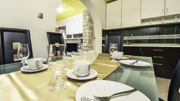A dining area with a glass table set for four, including plates, cups, and cutlery. - Apartment Anić by Interhome (Novigrad (Zadar))