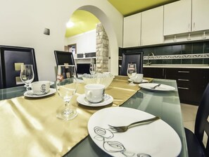 A dining area with a glass table set for four, including plates, cups, and cutlery. - Apartment Anić by Interhome (Novigrad (Zadar))