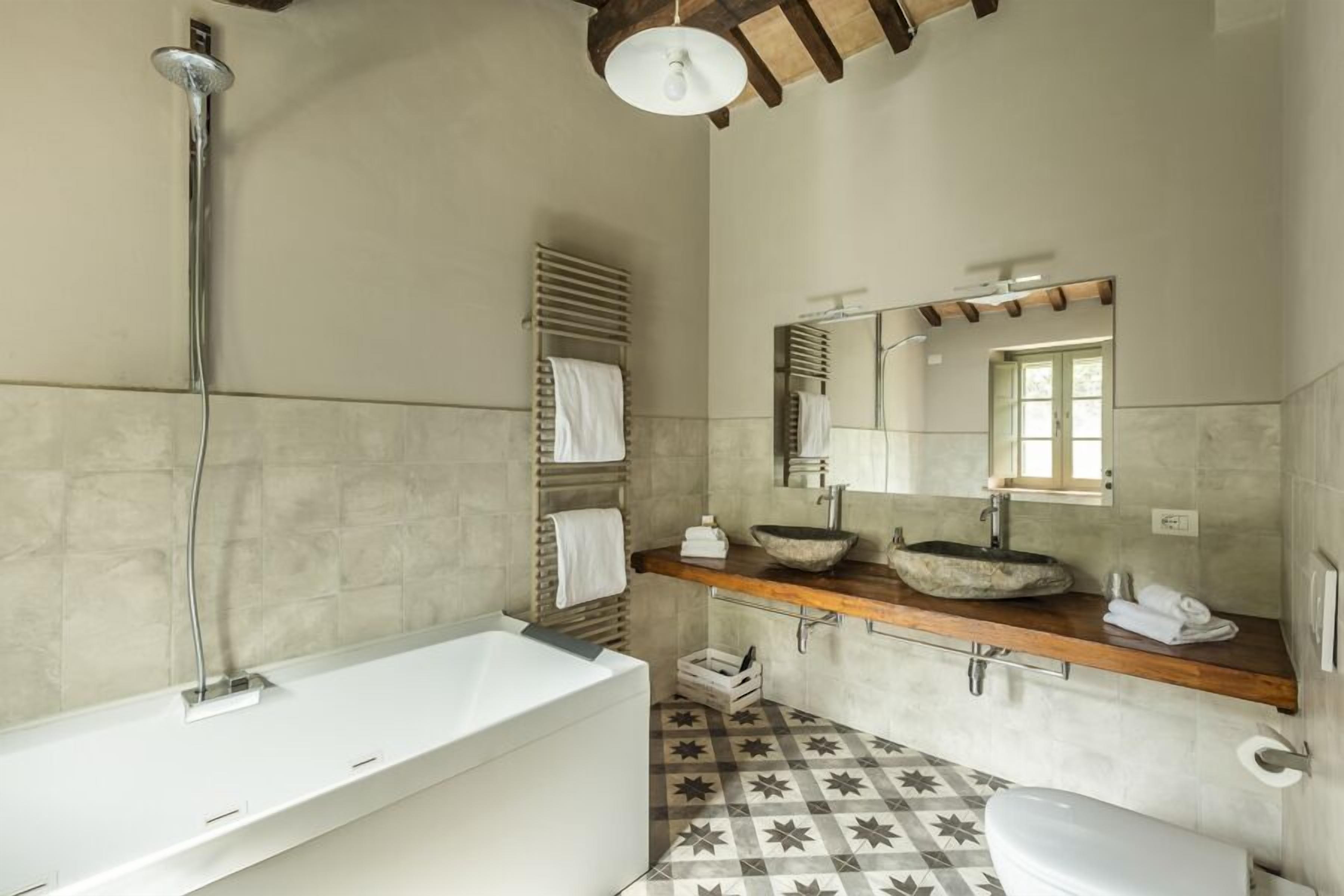 A modern bathroom with a freestanding bathtub, a large mirror, and a wooden vanity.