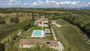 Un vaste domaine comprenant une piscine, un vignoble et plusieurs bâtiments.