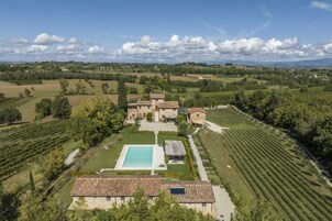 A large estate with a swimming pool, vineyard, and multiple buildings.