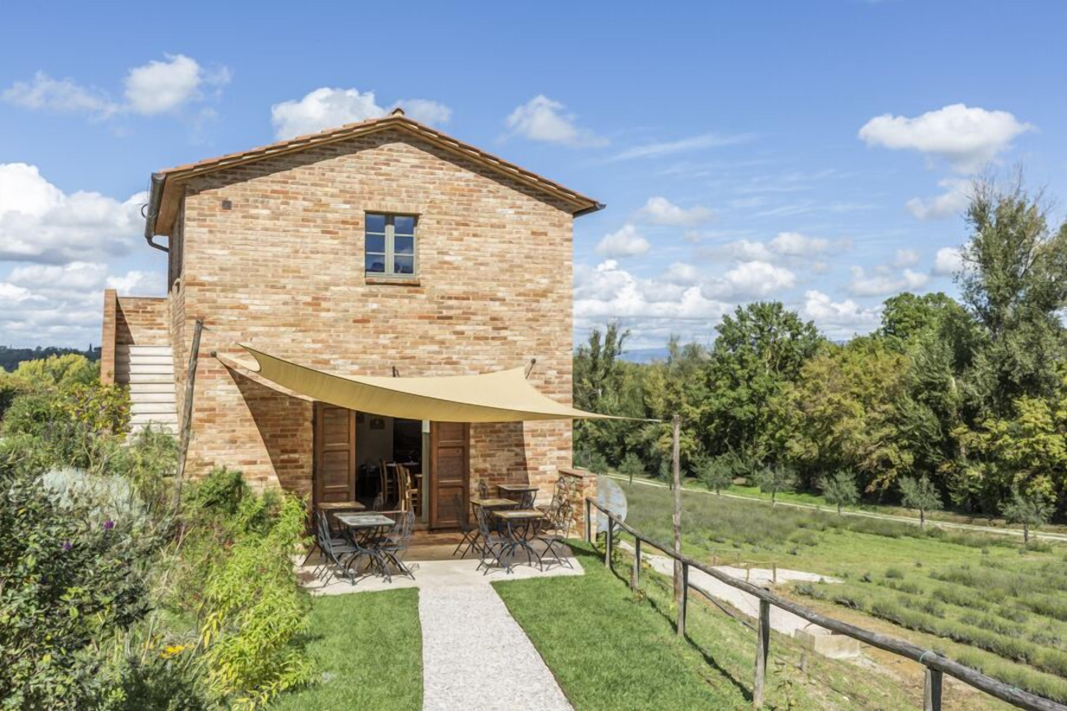 A stone building with a patio and outdoor seating area.