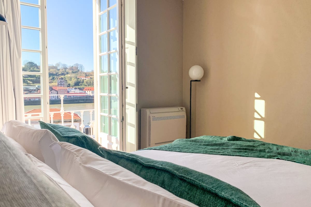 Un dormitorio con cama, ventana y radiador.