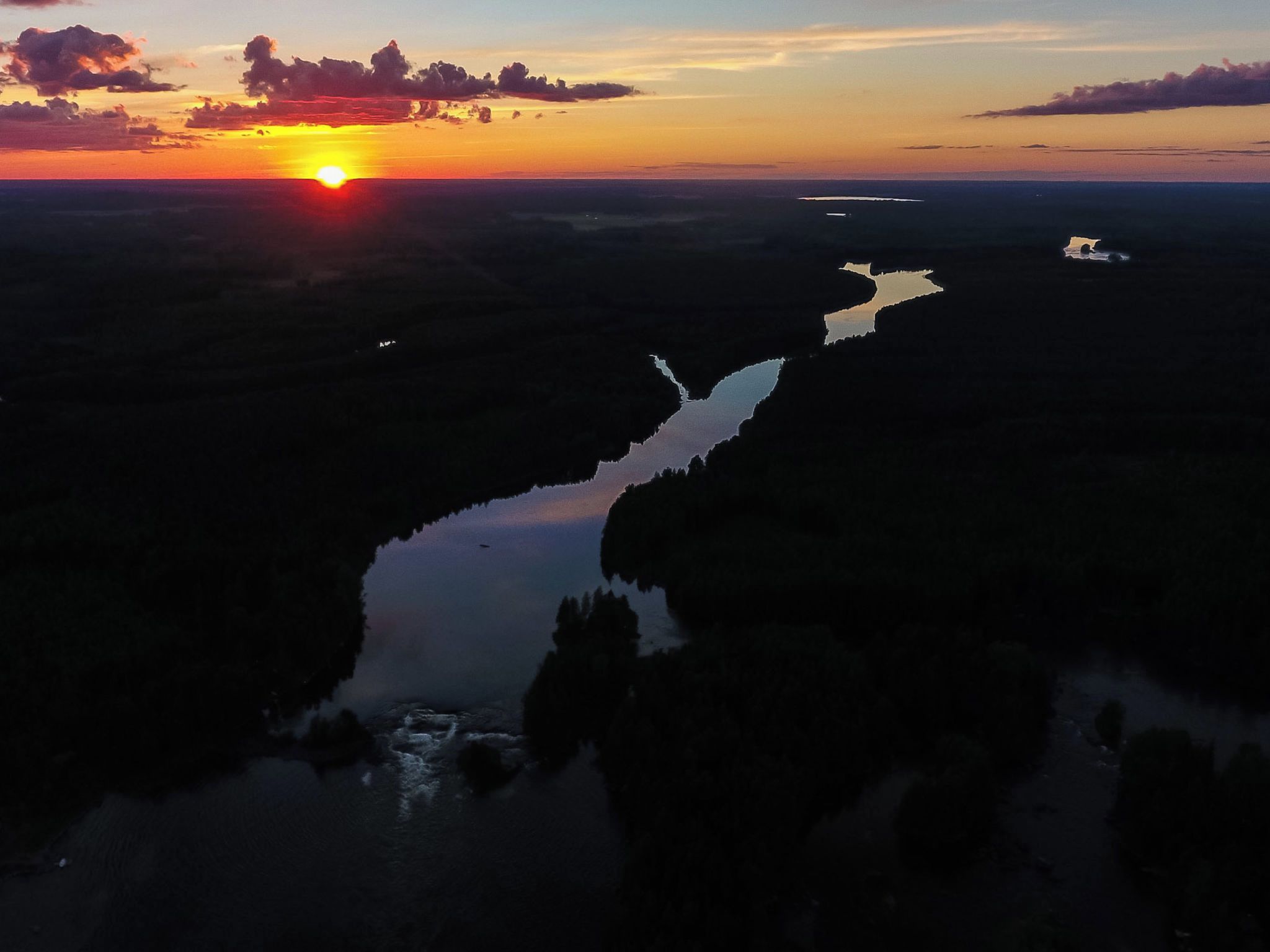 Une rivière qui traverse un paysage au coucher du soleil.