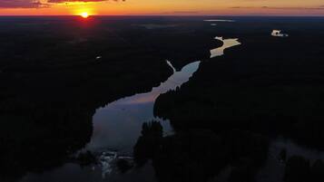 Une rivière qui traverse un paysage au coucher du soleil.