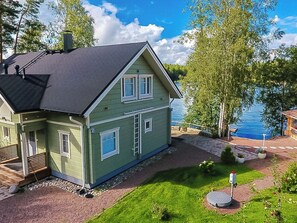A two-story house with a dark roof, green siding, and a front porch. - Huvila ferdinand by Interhome (Kotka)