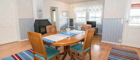 A dining area with a wooden table, chairs, and a built-in grill.