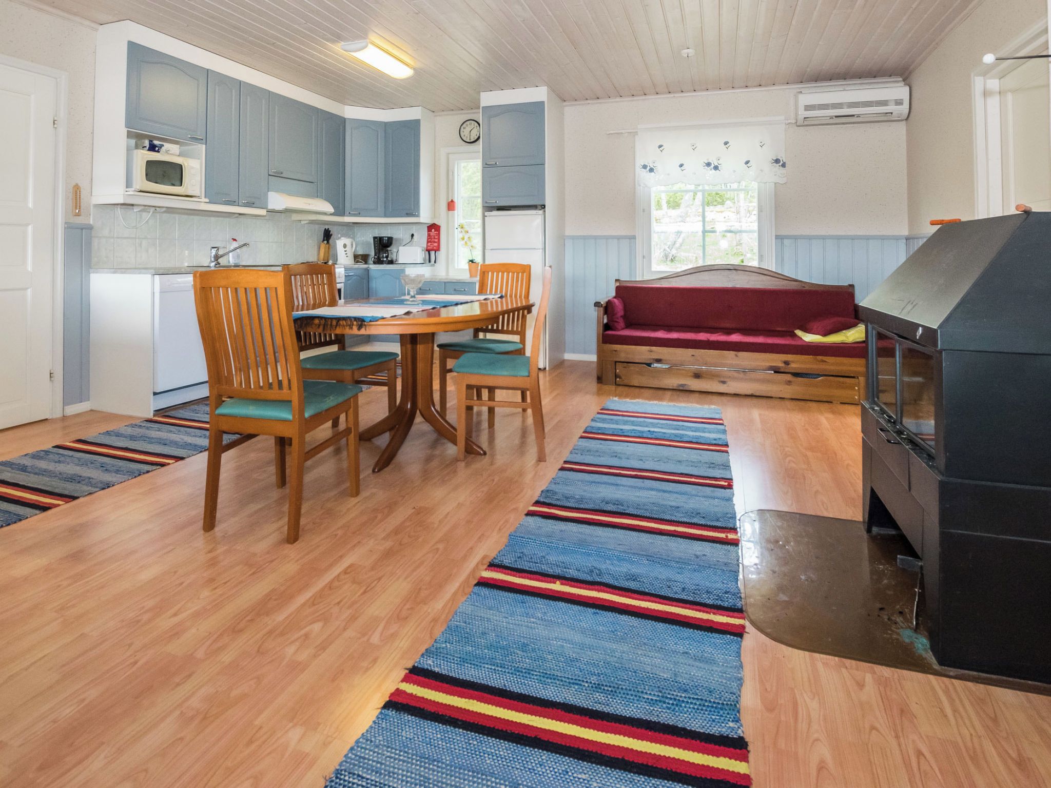 A compact kitchen with a dining area, a sofa, and a fireplace.