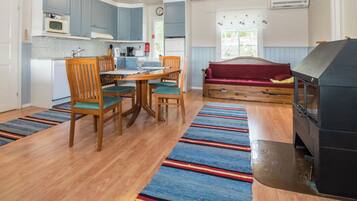 A compact kitchen with a dining area, a sofa, and a fireplace.