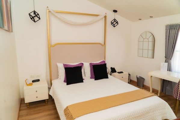 A neatly arranged bedroom with a four-poster bed, bedside tables, a desk, and a window with curtains. - Adamas House Hotel (Quito)