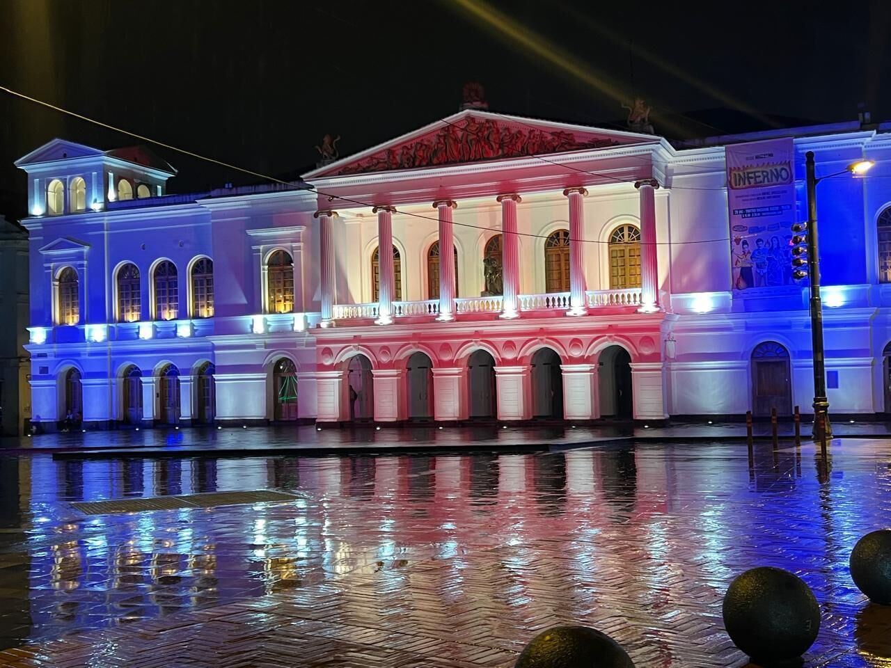 A historic building with classical architecture, featuring a central balcony and arched windows.