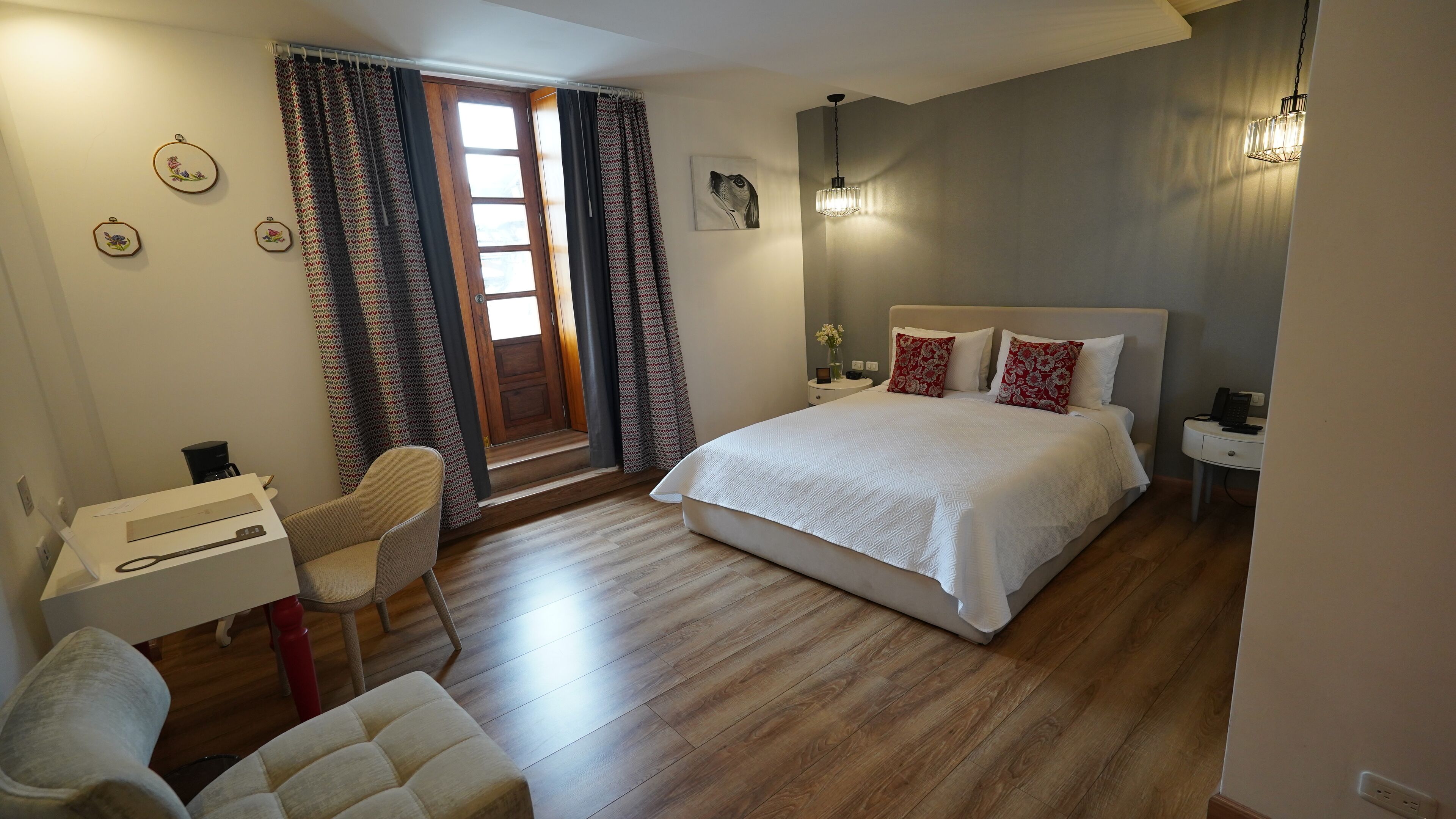 A bedroom with a bed, a desk, a chair, and a window with curtains.