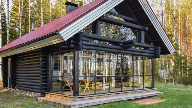 A log cabin with a glass extension, wooden deck, and a red roof. - Leporanta by Interhome (Kerimäki)
