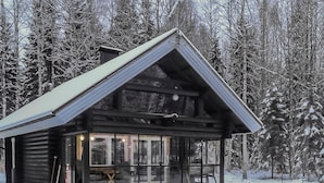 A log cabin with a large glass front, surrounded by snow-covered trees. - Leporanta by Interhome (Kerimäki)