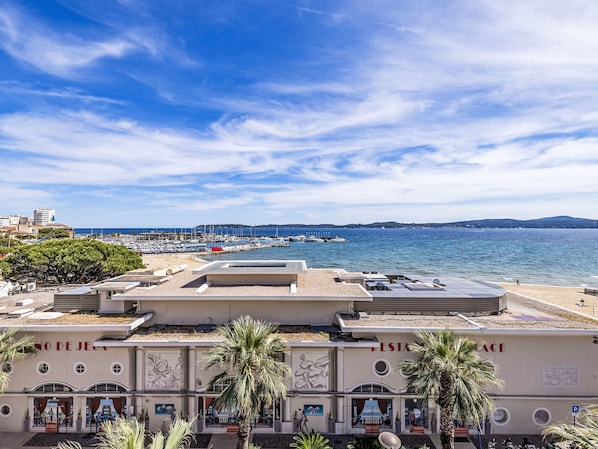 A coastal hotel with a rooftop terrace, a beach view, and a dining area.