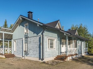 A two-story wooden house with a porch, a chimney, and a small attached garage. - Klz 1. akaatti by Interhome (Sotkamo)