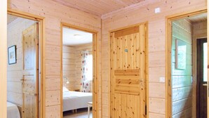 A wooden cabin with a bedroom, a bathroom, and a living area.