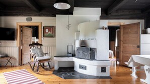 Een rustiek interieur met een stenen openhaard, houten meubels en een aan de muur bevestigde televisie.