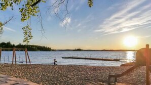 A beach with a swing set and a wooden structure, likely a gazebo, near the water. - Hästöskata b by Interhome (Kruunupyy)