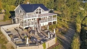 A two-story house with a balcony and outdoor seating area. - Hästöskata b by Interhome (Kruunupyy)