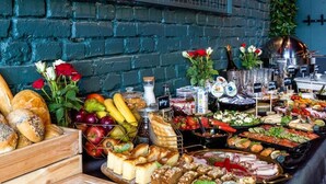 A buffet with various food items and a brick wall in the background. - Hotel Gdynia Boutique (Gdynia)